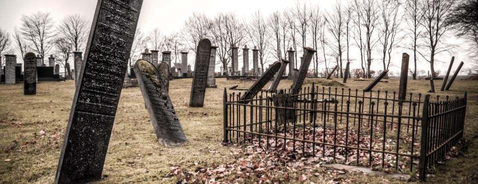 Ein Friedhof mit schrägen Grabsteinen.