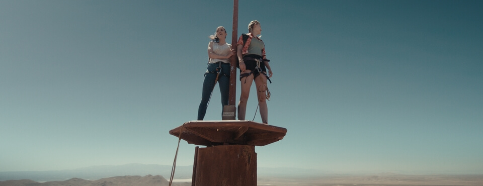 Zwei Frauen stehen auf einem Fernsehturm in der Wüste